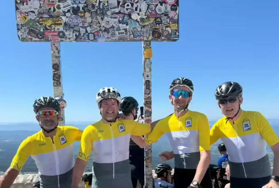 Four cyclists in Borne Cycling kit at the top of Mont Ventoux with the sign in the background.