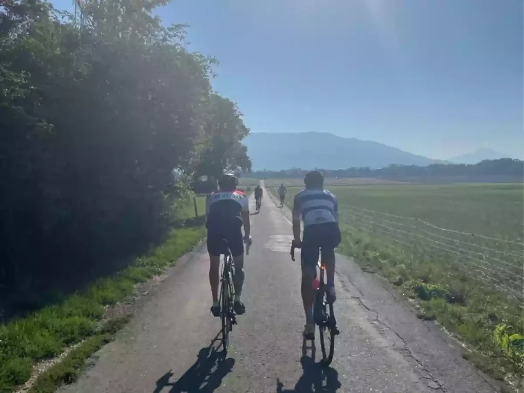 a group of cyclists riding on a sunny day towards Mont Salève in Canton Geneva.