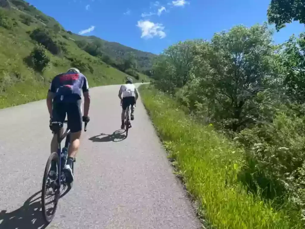 cyclists climbing mountain road blue sky