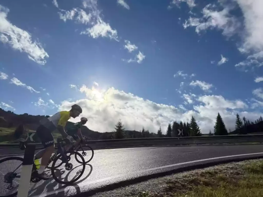 cyclists on passo campolongo at sunrise