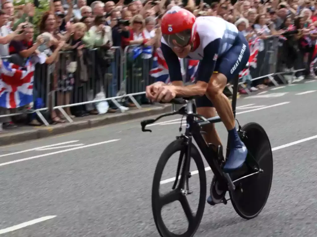 Bradley Wiggins on time trial bike with a large crowd watching