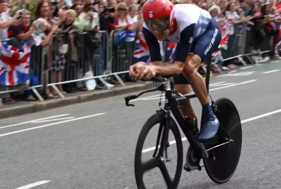 Bradley Wiggins on time trial bike with a large crowd watching