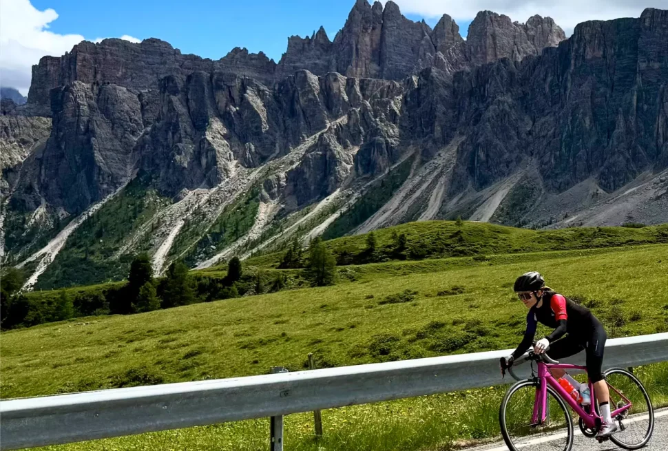 Cyclist descending at speed with big mountain range in the background